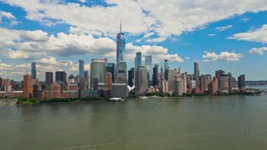 New York 'taki Manhattan ve One World Trade Center Weehawken New Jersey' den görüldüğü gibi. Manhattan 'ın gökdelenleri New York körfezinin dalgalanan sularının yanında mavi gökyüzüne karşı. NYC, ABD