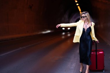 Bagajlı, bavullu, tatile çıkan modacı kadın. Seyahat yaşam tarzı. Seyahat çantalı turist kız şehir sokaklarında geziyor.