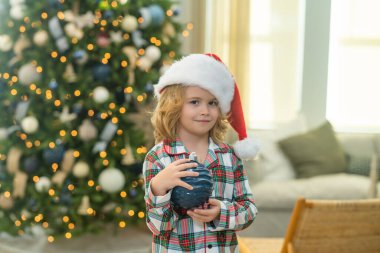 Noel 'i kutlayan küçük bir çocuk ya da evde Noel ağacı olan bir çocuk.