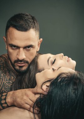 Seksi üçlü erkek ve iki güzel şehvetli kadın. Üçlü grup. Üç kişilik poliyamory. Üçlü 'nün romantik ilişkileri. Üçlüye tutkuyla sarılmak. Bir grup seksi model.