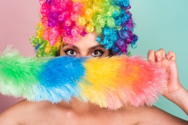 Gökkuşağı lgbtq bayrak peruğu takan genç kadın pozitif ve mutlu görünüyor. Komik kız gülüşü. Peruklu genç transseksüel kadın. Komik kadın suratı. Çekici, suratını buruşturan komik kızın portresi. Duygu Kadını