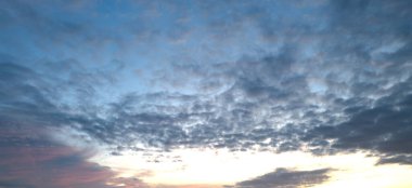 Gündoğumu arka planı. Dramatik günbatımı geçmişi. Gökyüzü bulutlu ve arka planda gökyüzü aydınlığı var. Farklı şekillerde bulutlarla gündoğumu. Sakin Gündoğumu