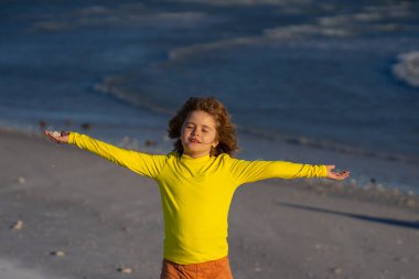 Mayolu çocuk yaz tatilinde deniz suyuna koşuyor. Çocuk okyanus boyunca koşuyor. Yaz plajındaki çocuk. Çocuk deniz suyunda bir yarış yapıyor. Çocuk deniz kıyısında sörf yapıyor. Yaz tatili