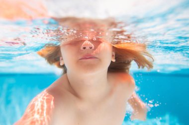 Yaz çocukları havuzda suyun altında. Çocuk su altında havuzda yüzüyor. Mutlu çocuk suyun altında yüzüyor, aktif çocuk yüzüyor.