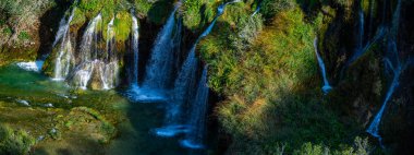 Plitvice Lakes Ulusal Parkı. Hırvatistan. Büyük şelaleler. Doğa yolculuğu geçmişi. Güzel doğa. Hırvatistan 'daki Plitvice şelaleleri. Dağ dereleri masmavi berrak suyla bir göle akar.