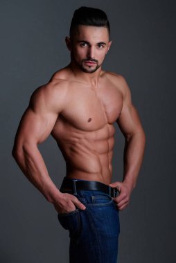 Kaslı üstsüz bir adam. Seksi erkek vücudu. Yakışıklı seksi model. Gömleksiz, kaslı erkek model. Çıplak gövdeli bir adam. Mükemmel vücut hatları olan kaslı genç bir adam. Seksi bir adam. Baştan çıkarıcı adam.