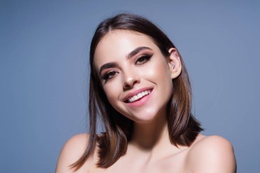 Gülen surat. Kadın yüzü mutlu bir gülümseme. Gülümseyen genç kızın yakın portresi. Dişleriyle gülümseyen, mutlu bir yüz ifadesiyle kameraya bakan genç bir kadın. Gülümseme. Gülen surat.