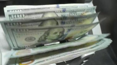Para sayma makinesini kapat ve dolarları say. Banknot sayacı. Dolar banknotları olan para sayacı. Para sayma makinesi 100 dolarlık banknotları sayıyor.