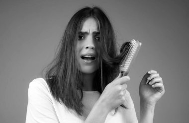 Saçını taramış, saçları sorunlu bir kadın. Saç dökülmesi stresli kadın ve kel problemleri