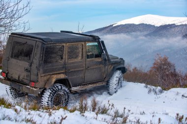 Dağlarda karlı yollarda. Kış karında off-road aracı. Kış ormanlarında yol dışı araç, karda sürüklenmek. Kar fırtınasında off-road arazi aracı. Arabalar off-road gezisi, kış off-road pisti