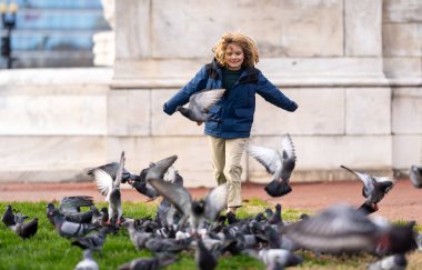 Mutlu çocuk güz gününde kuşları kovalıyor. Çocuk güvercinler için koşuyor. Tasasız çocuklar konsepti. Mutlu bir çocukluk. Mutlu bir çocuk parkta güvercin kovalıyor. Mutlu Çocuk güvercinlerle oynuyor. Tasasız Çocuk güvercinleri yönetiyor.