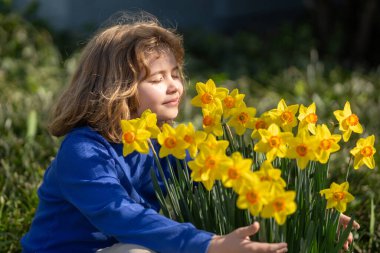 Adorable kid in spring garden. Happy childhood. Kids face near spring park. Kid Happiness. Childrens day. Cute little child under a blossom tree. Kid spring. Kids portrait in blooming cherry tree clipart