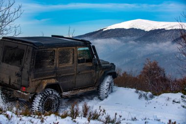 Kış lastikleri. Dağlarda karlı yollarda. Kar altında off-road aracı. Ormanda bir arazi aracı, karda sürükleniyor. Kar fırtınasında off-road arazi aracı. Otomobiller off-road gezisi, kış arabası 4x4 pisti