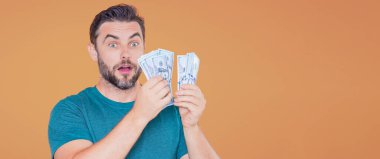 Nakit para tutan orta yaşlı bir adam. Büyük şans, afiş. Dolar nakit para konsepti. Nakit kazanınca seviniyor. Adamın elinde nakit para var.