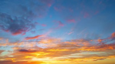 Güneşli gün batımı ve mavi bulutlar ve güneş ışınlı turuncu dramatik gökyüzü. Gece Gökyüzü zaman çizelgesi. Gün batımında hareket eden bulutlar. Akşam bulutları. Alacakaranlık gökyüzü zaman aşımına uğradı. Dramatik gökyüzü