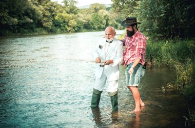Nehirde balık tutan iki erkek arkadaş. Yaşlı baba ve oğlu nehir kenarında olta balıkçılığı yapıyor. Eğlence etkinliği