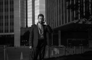 Beyaz, takım elbiseli bir iş adamı akıllı telefon kullanıyor. Seksi moda işadamı