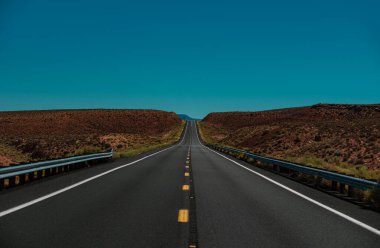 Uzun düz bir yol. Güneşli yaz gününde asfalt yol manzarası
