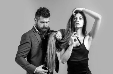 Uzun saçlı. Moda kesimi. Deriyi kurutmak için kurumuş vücut parçalarına merhem sür. Sakallı, şık berber dükkanı müşterisi