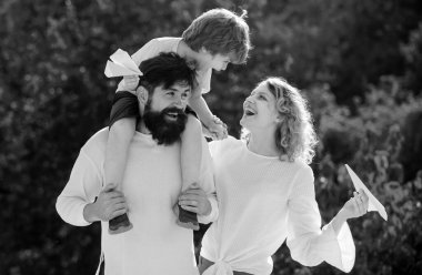 Güneşli bir günde basit kağıt uçaklarla oynayan çocuklar. Ailecek vakit geçireceğiz. Mutlu bir babanın portresi. Oğlunu sırtında taşıyor ve yukarı bakıyor.