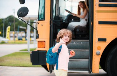 Okula ve mutlu zamanlara. Eğitim: Gülümseyen İlkokul öğrencisi otobüse binmeye hazır