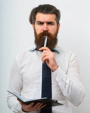 Yakışıklı bir iş adamı, elinde kalem ve defter tutan, beyaz arka planda soyutlanmış.