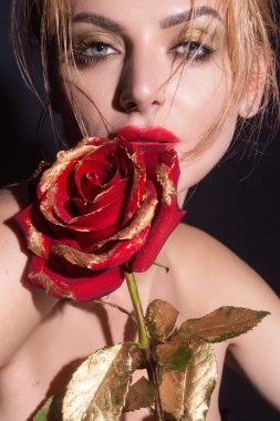 Sevgililer Günü. Kırmızı dudaklar altın güller. Güzel stüdyo portresi. Kırmızı gül çiçekli güzel bir model, siyah stüdyo arka planında izole edilmiş. Mükemmel makyajlı hoş bir genç kız.