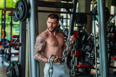 Handsome man preparing for workout. Sport. Weight workout. Guy doing bodybuilding workout in gym. Sport, bodybuilding and fitness. Man exercising with dumbbell. Hard workout
