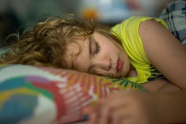 Çocuklar için yastık ve battaniye. Küçük çocuk uyuyor. Sevimli çocuk yatakta uyuyor. Uyuyan çocuk. Çocuk karanlık odada uyuyor. Evdeki bir yatakta uyuyan çocuk