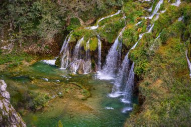 Plitvice Lakes Ulusal Parkı. Hırvatistan. Büyük şelaleler. Doğa yolculuğu geçmişi. Güzel yaz doğası. Hırvatistan 'daki Plitvice şelaleleri. Dağ dereleri masmavi berrak suyla bir göle akar.