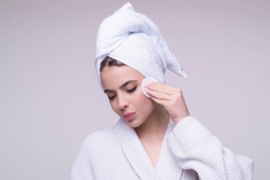 Woman cleansing skin by cotton pad sponge. Spa and wellness, skin care. Beauty routine. Beautiful girl cleaning face with cotton pad. Skin treatment, cosmetology