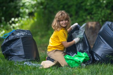 Çocuk dışarıda çöp topluyor. Ekoloji konsepti. Çevre kirliliği. Dünya Günü. Çöp tenekelerini geri dönüşümle temizleyin. Doğa temizliği. Çevre plastik kirliliği