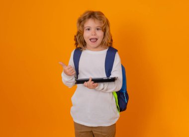Öğrenci, inek öğrenci. Tabletli okul çocuğu. Öğrenci okulda öğreniyor. İlkokul çocuğu. Stüdyo arka planında izole edilmiş inek öğrenci portresi..