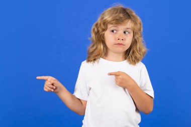 Çocuk mavi izole edilmiş stüdyo geçmişini işaret ediyor.