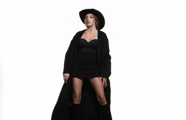 Şapkalı ve siyah ceketli bir manken. Stüdyoda şık bir kadın moda elbisesi giyiyor. Güzel bir kız moda kıyafetleri giyer. Günlük kıyafet, moda tarzı. Moda Modeli