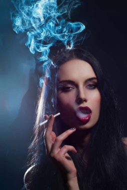 Sigara içen seksi kız. Dumanlı zarif bir kadın. Sigara içiyorum. Şehvetli Kadın, kırmızı dudaklar. Duman çıkaran güzel bir kadın. Sigaralı şık bir kız. Sigaralı seksi manken.