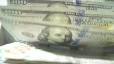 Finans ve nakit para kavramı. Elektronik para sayma makinesiyle dolar saymak. 100 dolarlık banknotlar para sayma makinesinde sayıldı. Banknotlar için nakit para.