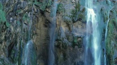 Plitvice Ulusal Parkı. Plitvice Gölleri. Şelale berrak mavi bir göle akıyor. Şelale huzurlu bir atmosfer yaratıyor.