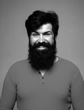 Berber dükkanında uzun sakallı ve bıyıklı bir adam. Mutlu erkek gülüşü