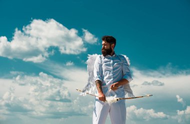 Sevgililer Günü 'nde ok atan komik, sevimli, yakışıklı adam. Aşk konsepti. Yakışıklı, çılgın, eğlenceli melek. Melek kanatlı Valentin sakallı adam. Sevgililer Günü