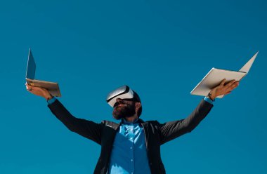 İş adamı sanal gerçekliği. Gelecekteki teknoloji konsepti. Dışarıda dizüstü bilgisayarı olan sakallı bir adam.