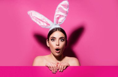 Komik duygular, heyecan verici ifade. Pembe üzerinde izole edilmiş tavşan kadın.