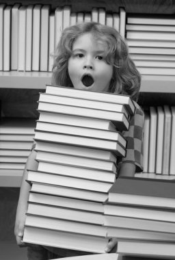 İnanılmaz okul çocuğu bir yığın kitap tutuyor. Okuluna geri dön. Çocuk inek öğrenci kütüphanede kitap okuyor. Sınıfta kitabı olan bir öğrenci. Okumak için edebiyat. Çocuk kitaplardan öğreniyor