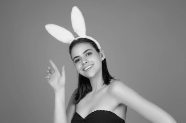 Paskalya kadını. Paskalyayı stüdyo arka planında kutlayan neşeli genç kız. Tavşan kulağı takan genç bir kadının stüdyo fotoğrafı. Neşeli tavşan.