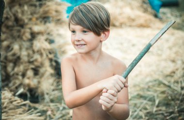 Çocukluk gruptaki. Köy zamanla. Çocuk ben sonbahar güneşli gün için hazırlanıyor. Çocuk bir sopa tarafından korunmaktadır