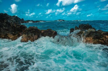 Dalga sahildeki kayaya çarptı, deniz suyu denize sıçradı. Deniz Burnu. Dalgalar kayalık kıyıya çarpıyor.