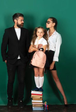 Baba öğretmen ve öğrencilerin portresi yeşil karatahta arka planda öğrenci kızları. Kitap okumak ve yazmak. Babam okulda kız öğrencilere ders veriyor.