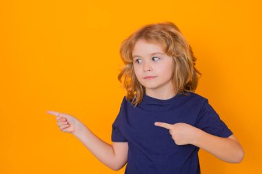 Çocuk sarı izole edilmiş stüdyo geçmişini işaret ediyor. Şok olmuş bir çocuk, reklam teklifleri sunuyor.