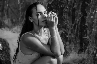 Yaz tatilinde doğa üzerine seksi bir model. Mayolu güzel bir kız suda seksi poz veriyor. Seksi yaz tatili. Egzotik ülke seyahati ve dinlenme konsepti. İnce vücut ve seksi vücut.