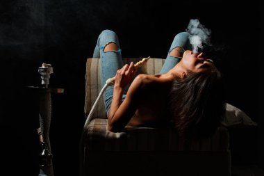 Nargile tüttüren seksi çıplak model. Nargile gece hayatını tüttürür. Gece kulübü nargile salonu. Lüks bir gece kulübü. Nargile salonu atmosferi